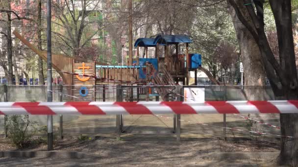 ヨーロッパ イタリアミラノ 2020年3月 公園内の子供たちのための学校や遊び場の閉鎖 自治体の命令で警察のテープでブロックされた遊び場 — ストック動画