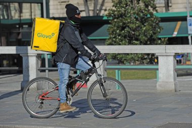 Milan, İtalya 15 Şubat 2018 - bisikletle yemek teslimatı - restorandan yemek siparişi vermek ve evde veya ofiste yemek - paket alıp götürmek, n-cov19 Coronavirus salgını sırasında devam ediyor