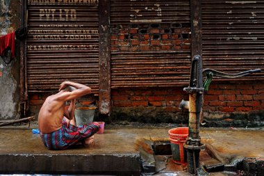 Hindistan 'da su kaynağının yakınında yıkanan bir adam.