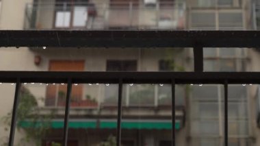 Covid 19 karantina Coronavirus ev tecridi sırasında sağanak ve sağanak yağmur yağdı. Binalar arasındaki evin balkonuna yağmur damlaları düştü. 