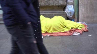 Milan, İtalya - 26 Aralık 2019: Evsizler sokakta uyur ve insanlar yürür