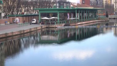 ITALY, MILAN FEBRUARY 3.2020 - Şehrin şehir merkezindeki Navigli kanallarında insan ve turistlerin yürüdüğü taş köprü