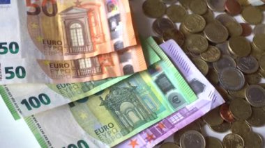 Euro para banknotları ve paralar beyaz bir masa üzerinde nakit
