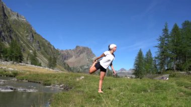 Dağlarda yoga yapan bir kadın.