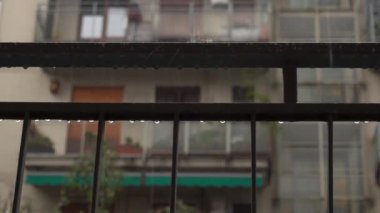 Covid 19 karantina Coronavirus ev tecridi sırasında sağanak ve sağanak yağmur yağdı. Binalar arasındaki evin balkonuna yağmur damlaları düştü. 