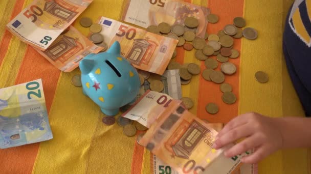 Dziecko Trzymające Pieniądze Pobliżu Skarbonki — Wideo stockowe