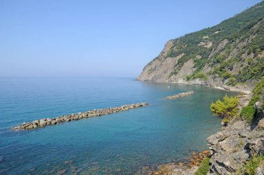 Dağların arkasında gölü ve kayalık plajı olan güzel körfez.