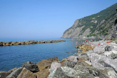 Dağların arkasında gölü ve kayalık plajı olan güzel körfez.