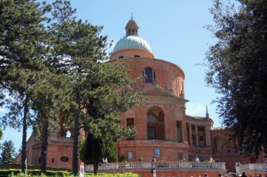 Parlak güneş ışığında kubbeli eski bir bina.