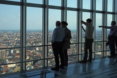 Turistlerin siluetleri terastaki manzaranın tadını çıkarıyor.