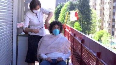 Avrupa, İtalya, Milano - Coronavirus Salgını - 70 yaşındaki maskeli yaşlı bir kadının evlerinin balkonunda saç kesimi yapan bir İtalyan kadını karantinaya aldı