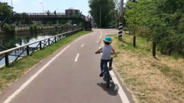 İtalya, Milan - Mayıs 2020: 19 Coronavirus nedeniyle karantina evi tecridi sona erdi - bisiklet yolundaki çocuk ve Navigli kanallarındaki maskeli insanlar - şehir merkezinde sürdürülebilir hareketlilik