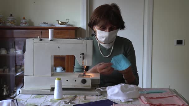 イタリア ミラノ 老婦人は Covid 19コロナウイルスの間にミシンで自家製のマスクを縫って修理します 家庭やライフスタイルでの隔離 シームレスで生産されたマスク — ストック動画
