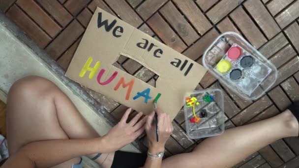 美白缎子女子举着标牌 我们都是人类 的抗议和明确表示 种族主义和社会暴力的概念 — 图库视频影像