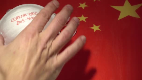 中国の国旗の背景に白いマスクにコロナウイルスの標識があり — ストック動画