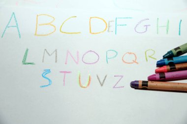 Alfabe harflerini yazmayı öğrenin. Çocuklar ilk okul günlerinde renkli kalemlerle yazar.
