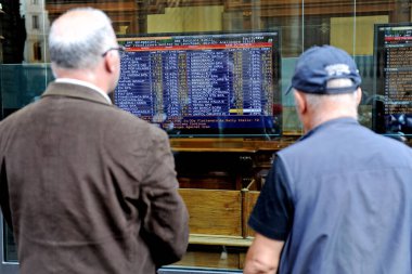 Italy, Milan - March 1, 2018: economic crisis - people look at the stock market indices in a bank clipart