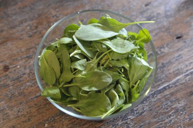 Tahta masadaki taze yeşil salata yaprakları.