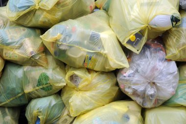 İtalya, Milan 15 Aralık 2019 - kaldırımda çöp torbaları ve yürümeye çalışan insanlar - farklı atık toplama için şeffaf torbalar