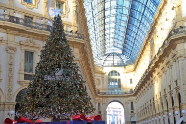 Avrupa, İtalya, Milan Aralık 2020 - Vittorio Emanuel Galerisi 'ndeki Swarovski Noel ağacı, Covid-109 Coronavirus salgını sırasında Duomo - maskeli insanlar alışveriş için yürüyorlar