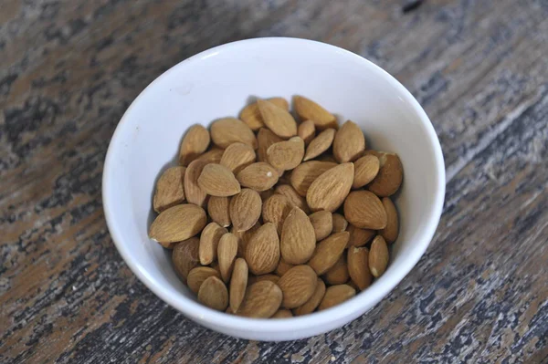 Almond Dalam Mangkuk Latar Belakang Kayu — Stok Foto