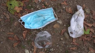 4K, tıbbi maske sokakta yerde. Kullanılan cerrahi maskelerin uygunsuz bir şekilde atılması