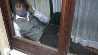 40 yaşında karantinada çalışan bir iş adamı koruyucu maske takarak evden çalışıyor. 19 yaşındaki Coronavirus küresel salgını, umutsuzluk ve ekonomik kriz sırasında akıllıca çalışıyor.