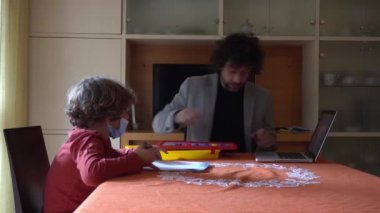 6 yaşında bir çocuk babasından ders alıyor. Covid-19 Coronavirus karantinası nedeniyle okulu kapatmış.