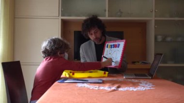 6 yaşında bir çocuk babasından ders alıyor. Covid-19 Coronavirus karantinası nedeniyle okulu kapatmış.