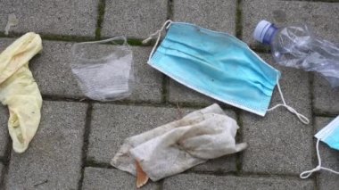4K, tıbbi maske sokakta yerde. Kullanılan cerrahi maskelerin uygunsuz bir şekilde atılması