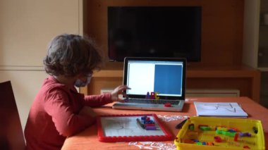 6 yaşında bir çocuk babasından ders alıyor. Covid-19 Coronavirus karantinası nedeniyle okulu kapatmış.