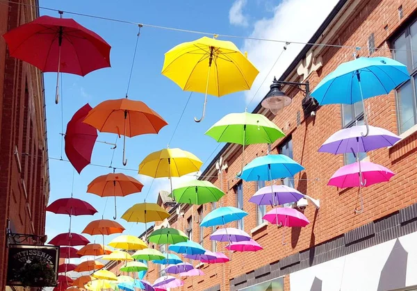 Parlak renkli gökkuşağı şemsiyeleri İngiltere, Newcastle yakınlarındaki bir caddenin üzerinde asılı..