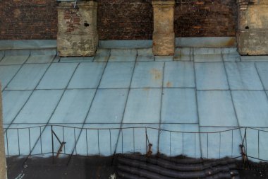 Büyük bir şehirde, duvarları ve bacaları olan eski bir evin çatısında.