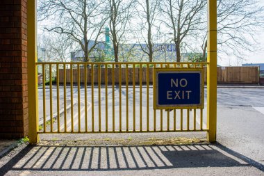Trowbridge Wiltshire kasabasındaki çok katlı bir otoparkın girişindeki sarı parmaklıklarda mavi bir çıkış işareti yok.