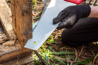Dikey çerçeve kerestesinin bir parçasını kesmek için kullanılan bir el testeresi.
