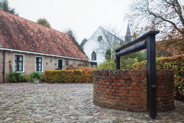 Small house with well in Bourtange, a Dutch fortified village in the province of Groningen in the north of the Netherlands