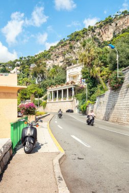 Villefranche-sur-Mer, Fransa, 4 Eylül 2018: Saint-Jean-Cap-Ferrat yönünde bir motosikletçi ve skuter binici-Boulevard Napoleon III Villefranche-sur-Mer