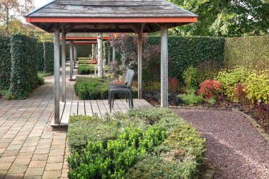 Sekiz renkli küçük dört arbors güzel sonbahar bahçe Hollanda güneşin tadını çıkarmak için sandalye