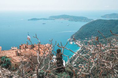 Fransa'da ufukta Saint-Jean-Cap-Ferrat yarımadası ile pitoresk ortaçağ köyü Eze çatıları üzerinde Akdeniz'de görünümü 
