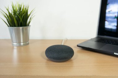 Masa arka planında sanal ses asistanı aygıtı