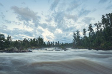 Wabigoon Nehri, akan nehrin kıyısından gün batımında akıntıya kapılır..