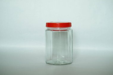 Kırmızı kapaklı ve cam kapaklı boş bir kap.