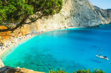 Porto Katsiki Beach'te Lefkada Adası, Yunanistan. Güzel manzara plaj üzerinde. Su turkuaz ve sahilde turistler ve denizin bir teknede vardır.