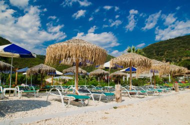 Antisamos beach Kefalonia island, Yunanistan. Saman şemsiye (şemsiye) ve güzel bir plajda şezlong.