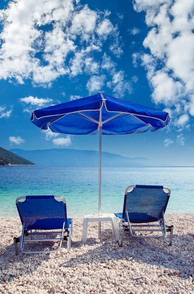 蓝色的伞和晒黑床在海滩上 希腊美丽海滩上的遮阳伞和日光浴床 — 图库照片