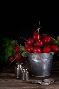 Bir demet taze ıslak turp eski bir ahşap masa. Köy tarzı. Karanlık anahtar fotoğraf.