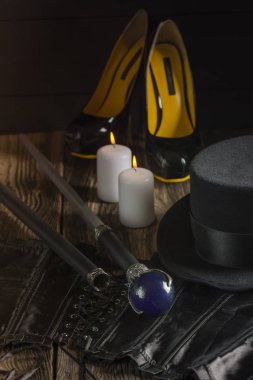 Seksi kadın bdsm metresi kiti. Siyah korse, stiletto topuklar, silindir ve kamışı. Karanlık fotolar.
