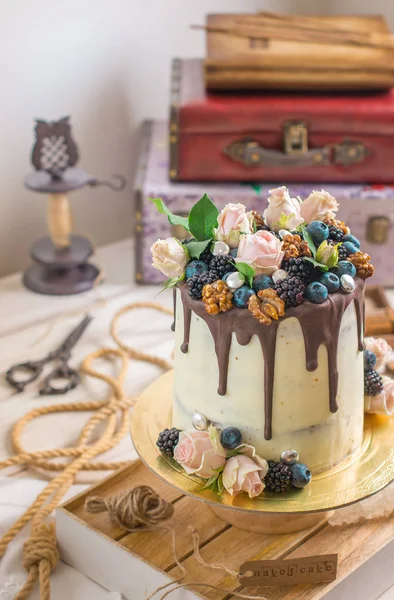 Çıplak kek dekore çiçekler, fındık ve çilek tarafından beyaz çıplak pasta, düğün, Doğum günü ve Etkinlikler için rustik tarzı. Üstten görünüm.