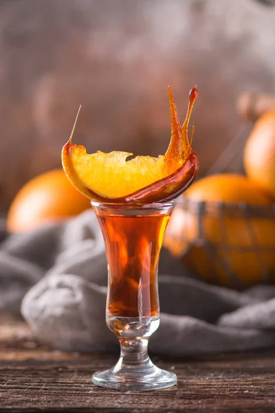 Orange cocktail in a stack with a slice of orange covered with caramel. Close view. Selective focus.