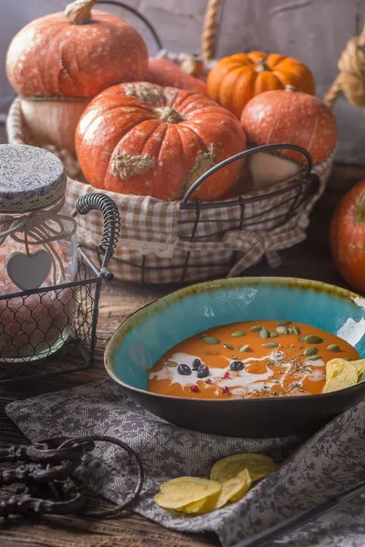 Krem ve koyu ahşap zemin üzerine maydanoz ile kabak çorbası.